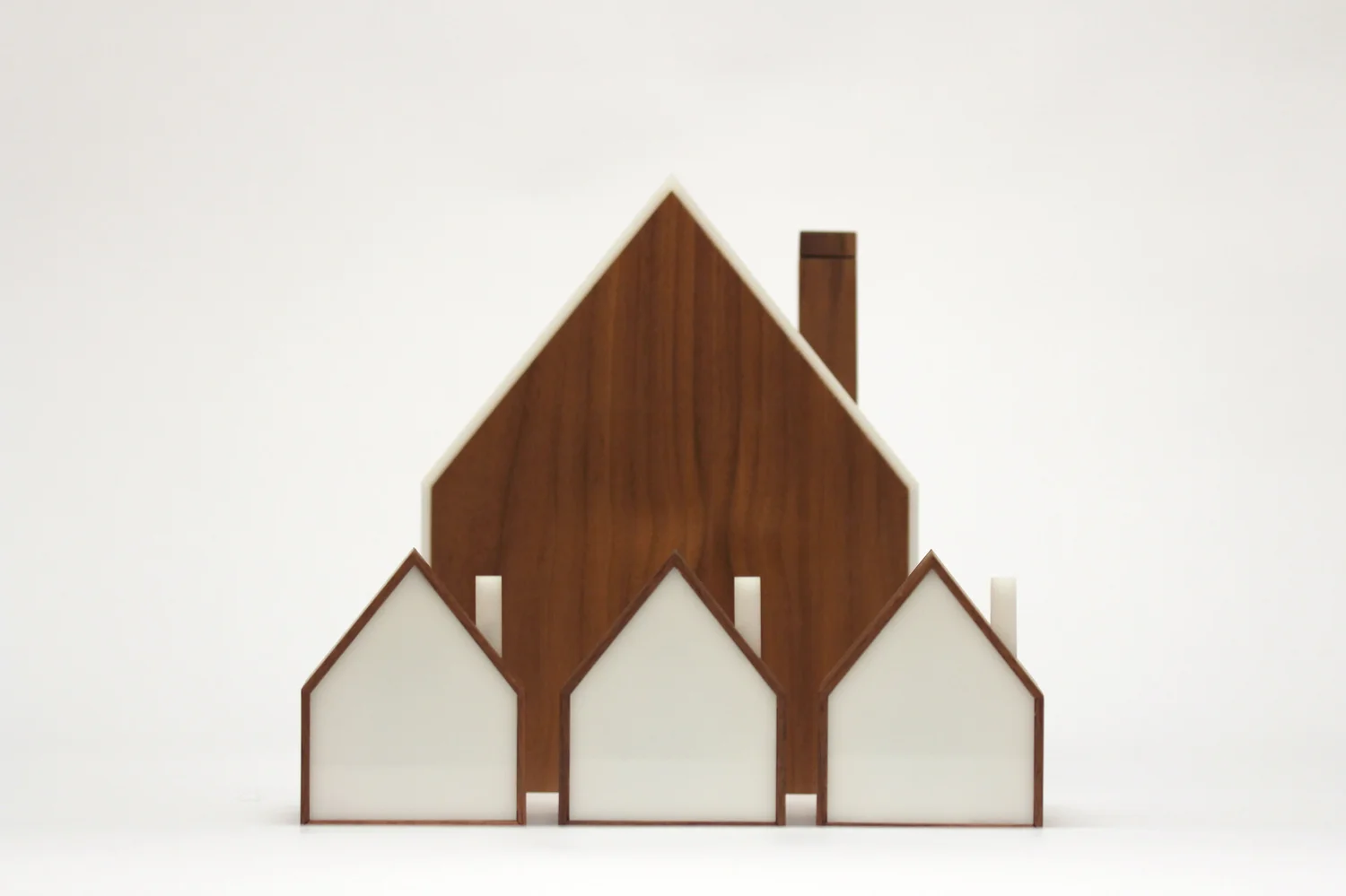 One large wooden house-shaped Good Night Lamp behind three smaller lamps with white fronts.